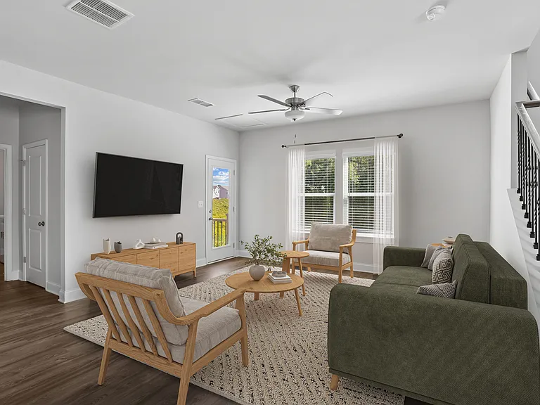 Living room with large couch, accent chairs, and windows.