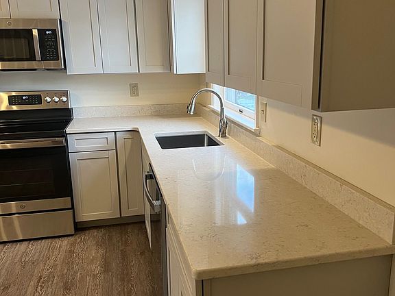 Under cabinet sink with one-piece quartz countertop.