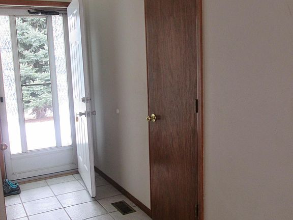 Front door with coat closet and entry to garage
