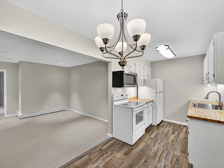 Welcome home with this view of kitchen, dining area and living room from front door. Many updates throughout the unit, including fresh paint and brand spanking new carpet in all rooms and closets!