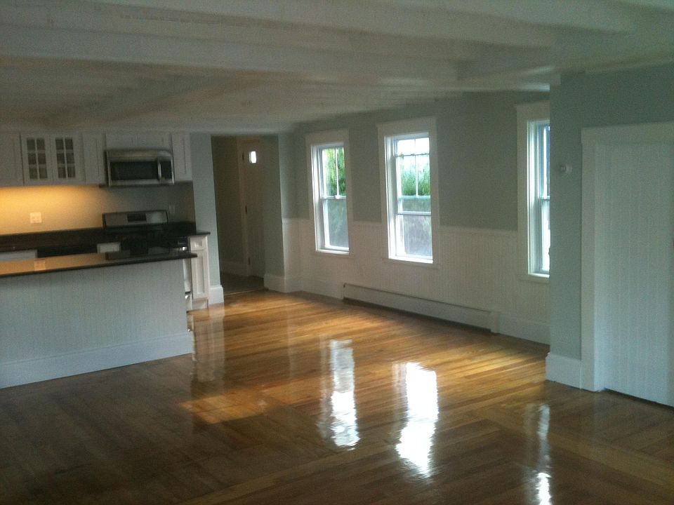 Open kitchen/dining/living with large space and hardwood floors. Door to full basement at right.