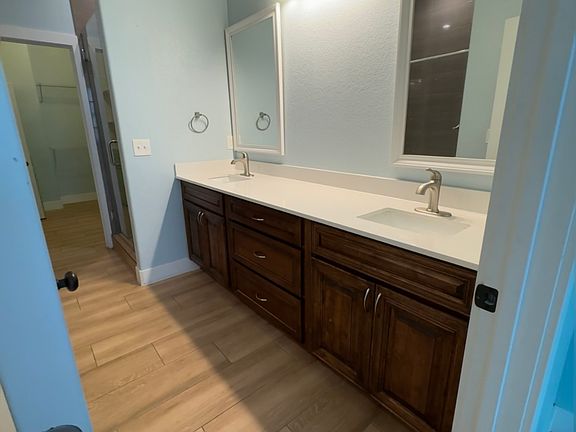 Master bath with shower and bath tub also with shower and his and hers sinks