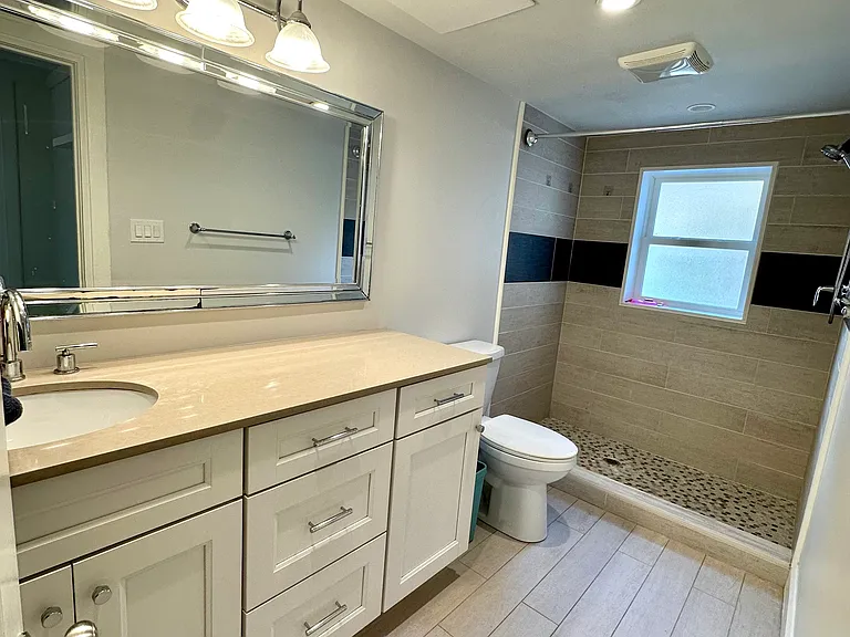 En suite bathroom with shower, in primary bedroom