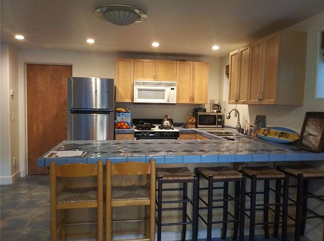 Full kitchen with bar and barstools