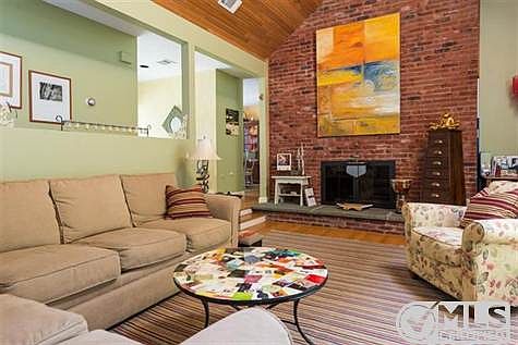 Living room with wooded cathedral ceiling and slider to deck.