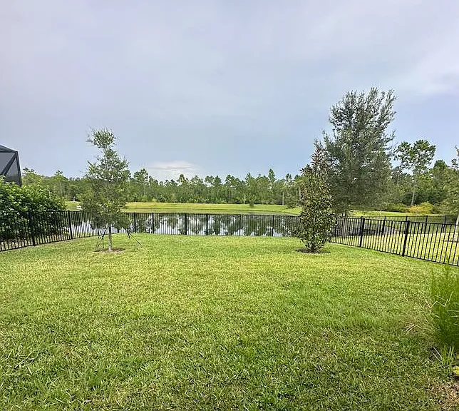 This is a photograph of our backyard. It is a fenced yard with two gates.