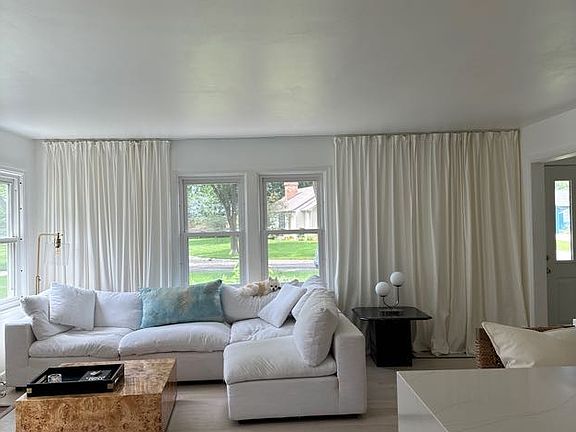 Main level living room with indoor fireplace and cloud couch.