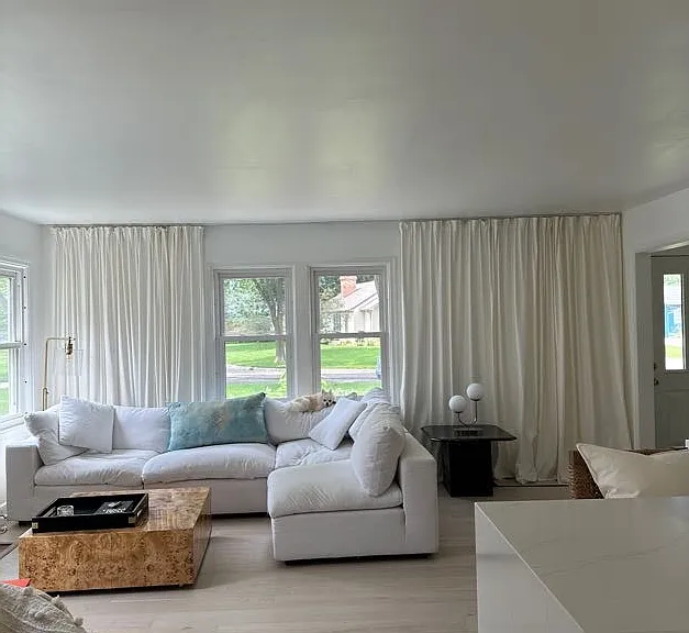 Main level living room with indoor fireplace and cloud couch.