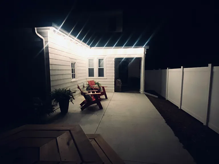 Nighttime view of private back patio accessible from living room door.