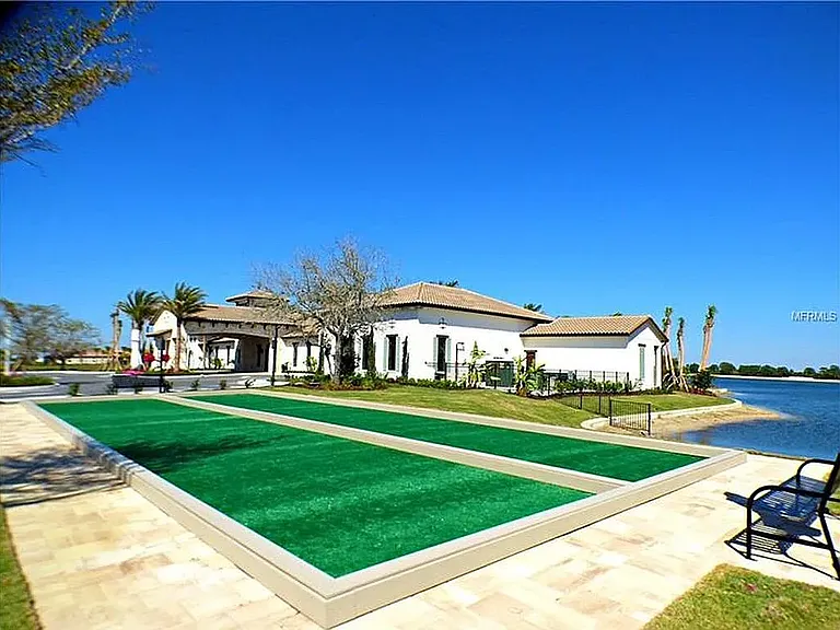 Distant view of club house and bocce courts. Resort style club house with gym, library, yoga classes, pool room, and table tennis. All within walking distance from the house.