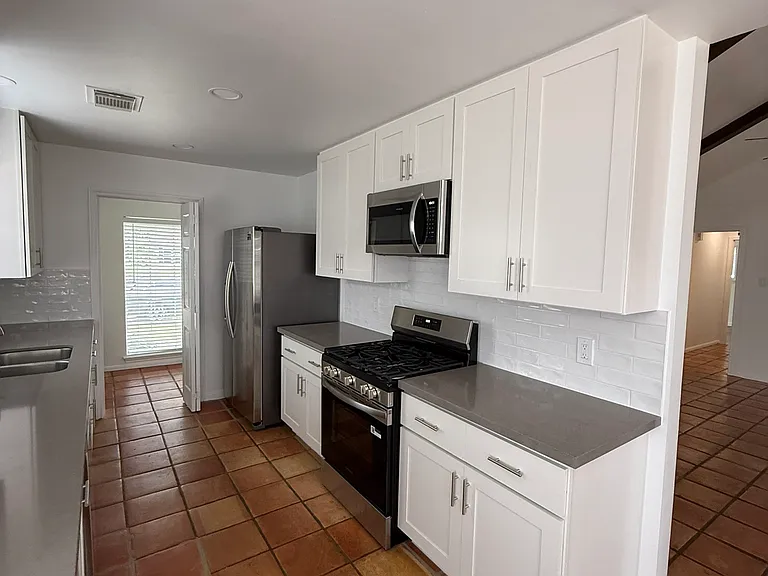 Kitchen with new appliances - gas range, microwave, fridge