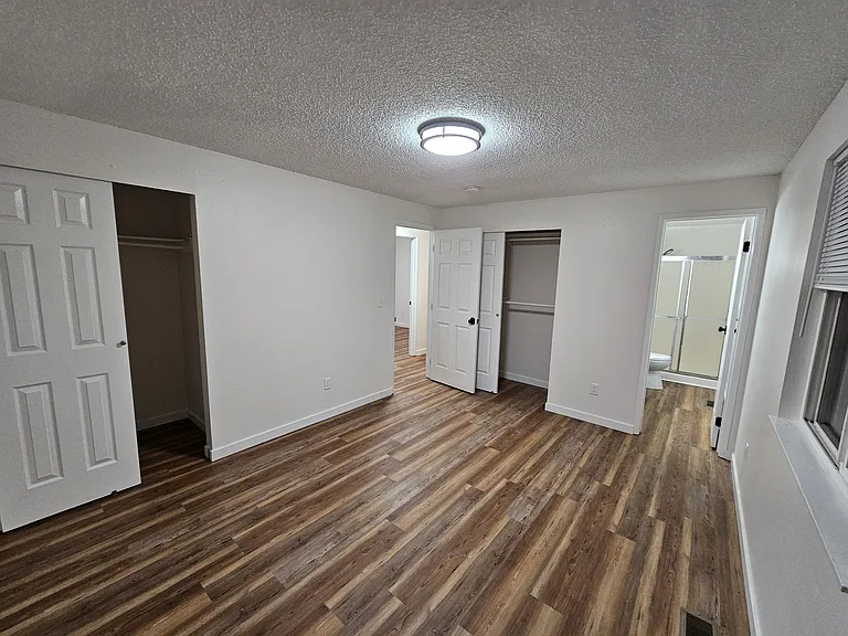 Primary bedroom with two closets and adjoining primary bathroom.