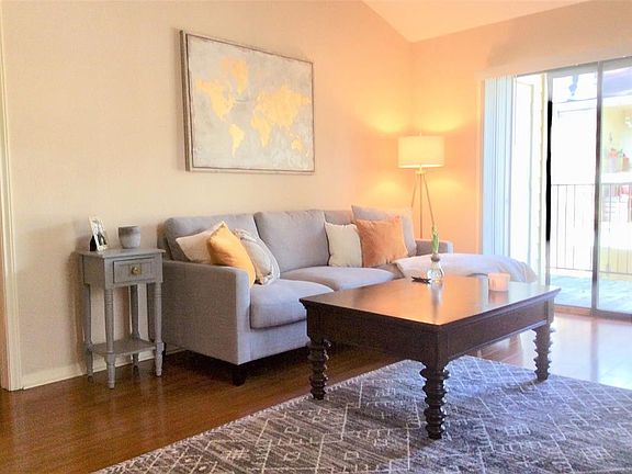 Light and bright living room with door leading to private balcony with outdoor storage room.