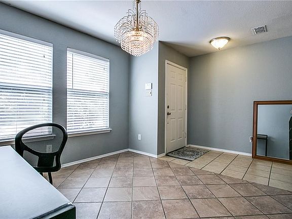 Formal dining and entry with large windows looking into the nicely manicured neighborhood.