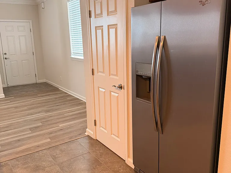 Kitchen with view to front door entry. Pantry provides ample storage.