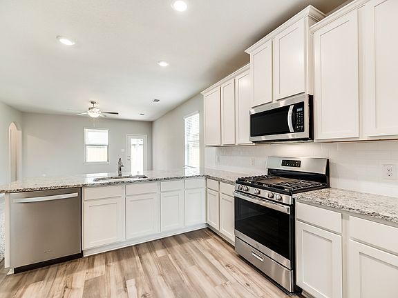 Enjoy stunning granite countertops and designer wood cabinetry in this kitchen.