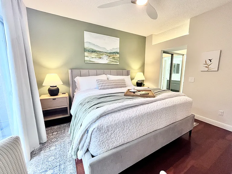 Primary Ensuite with plush king bed and luxe furnishings. Features a mirrored walk-in closet plus extra mirrored closet, 65" Smart TV, and a fully equipped workstation perfect for relaxing, working remotely, or unwinding after a day of exploring.