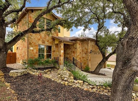 Stone and stucco exterior with xeriscaped yard with uplighting.