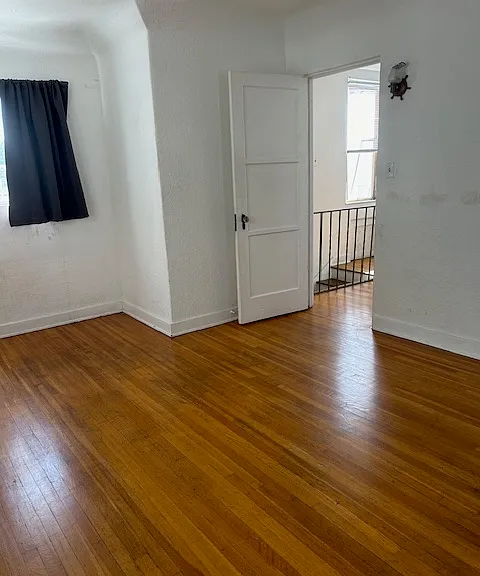 2nd floor bedroom with window facing south and door leading out to the 2nd floor platform