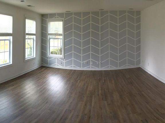 Pano view of 1st floor bonus living area with feature wall. Coat closet and Garage entry.