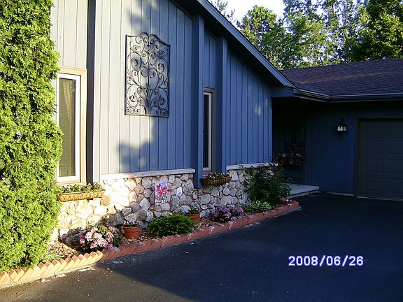Front of home with flowerboxes and ironwork sculpture