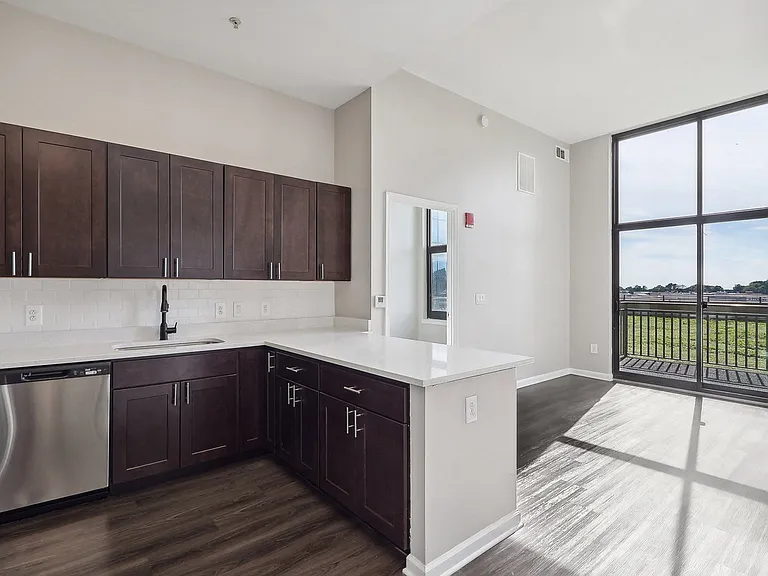 Kitchen with dark brown cabinets, stainless steel appliances and large window