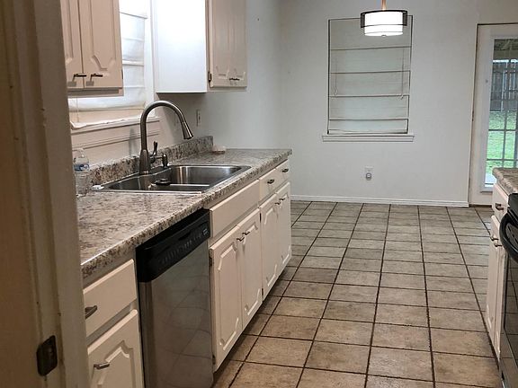 galley kitchen with dining room overlooking the backyard