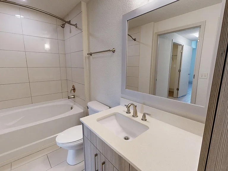 Apartment bathroom with soaking tub and LED lighted mirror.