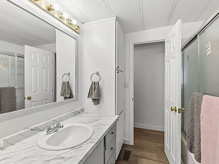Hall Bath. New shower and tub. new flooring. New sink and cabinet. Freshly painted gray and white. Linden cabinet for lots of storage.