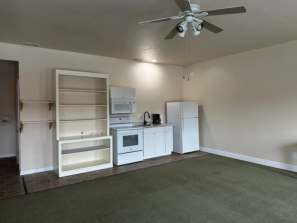 Studio Kitchen with Stove, Microwave, cabinets and refrigerator
