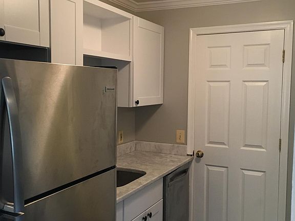 Kitchen with moldings, white shaker cabinets and granite countertops