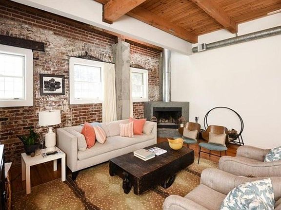 The living room area has open brick and a wood-burning fire 