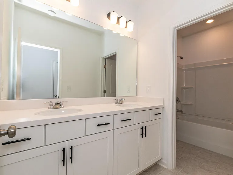 Secondary bathroom with tub shower and double vanity.