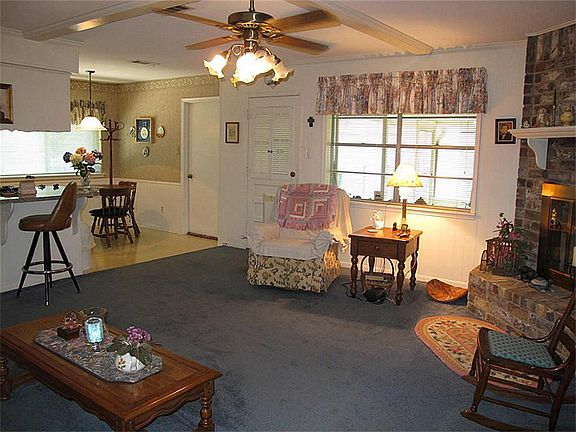 Supersized family room features majestic corner gas log fireplace, ceiling fan with light fixture, pretty valances, & plenty of space for even the largest of furniture settings!