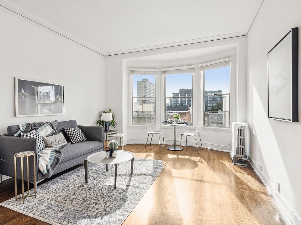 Living room that has a cozy with pillows and a blanket, along with a coffee table on a rug