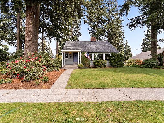 To the left of the left-hand stand of trees in the detached garage/shop.