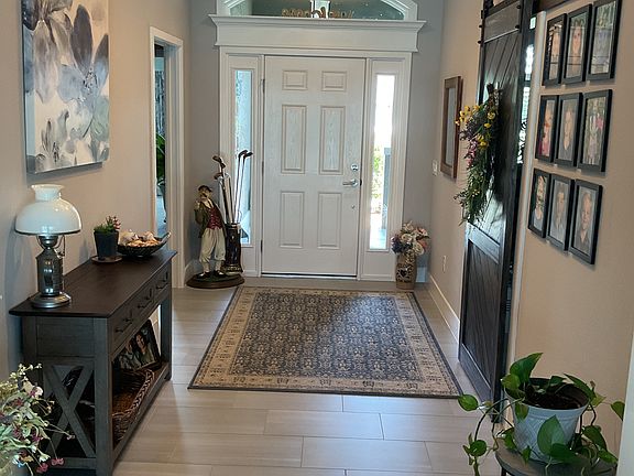View of foyer. Two bedrooms with bathroom on left with pocket door to secluded this guest suite. 
On the right is the 4th bedroom, with a queen Murphy bed and office space with desk chair. There is the 3rd bedroom here with a barn door secluding it