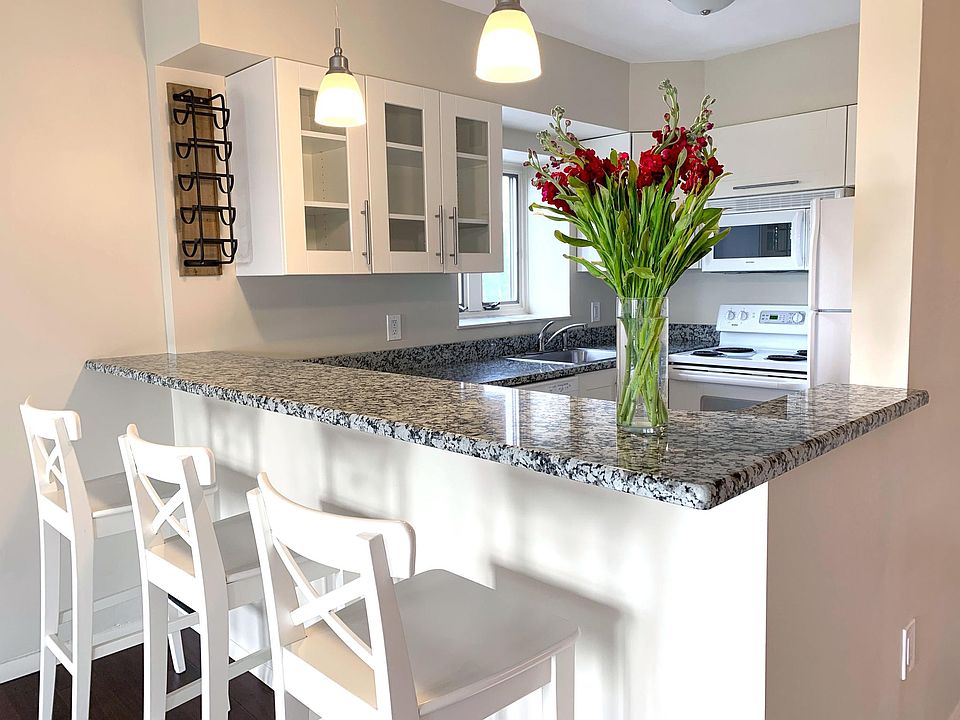 Open, bright kitchen with bar and granite countertops