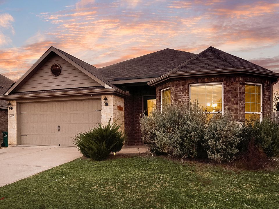 Stunning Denton house with concrete driveway, brick siding, and an attached garage!
