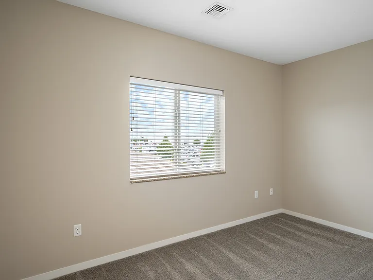 Bright and inviting bedroom with plush carpet and a window offering natural light. Bright and inviting bedroom with plush carpet and a window offering natural light.