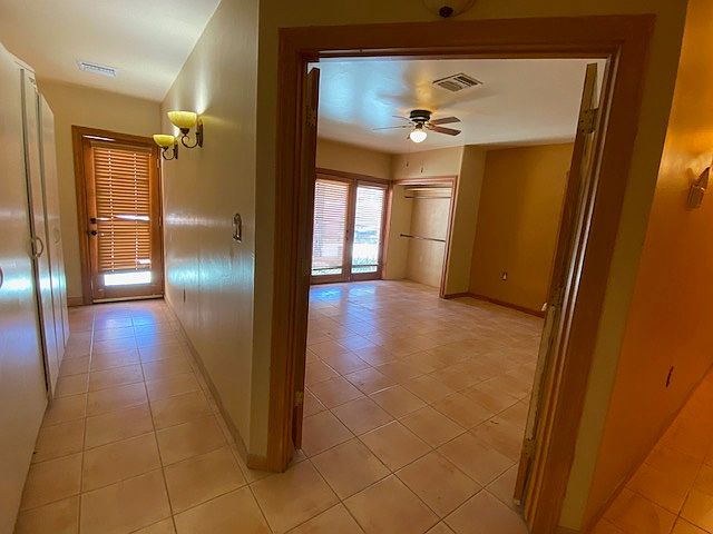 Large room with French Doors and hallway to out side patio with extra storage cabinets
