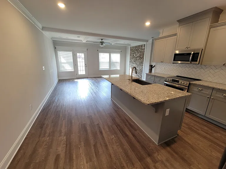 Open kitchen with stainless steel appliances and granite countertops