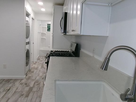 Kitchen stackable full laundry. bath in the back