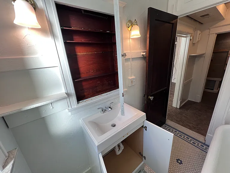 Plenty of bathroom storage with built in shelving, medicine cabinet, and vanity cabinet.
