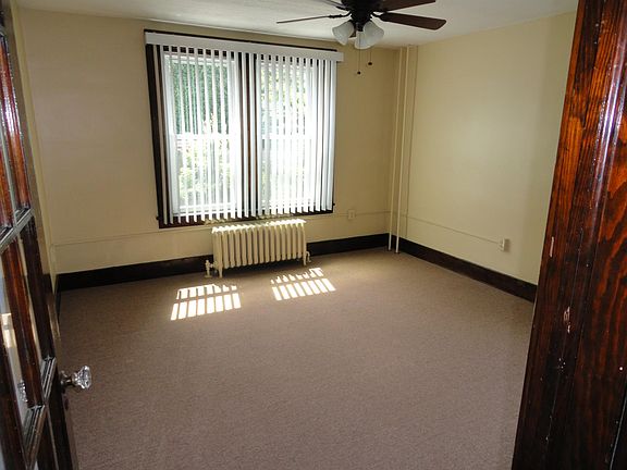Bright corner living room with paneled glass door. Vertical 