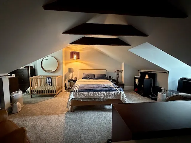 Third-floor media/flex space (currently shown with a bed for scale). Please note: Due to Pittsburgh egress window codes, this space does not qualify as a legal bedroom and is leased strictly as a bonus room/studio.