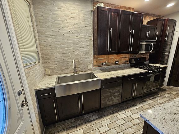 Beautiful intricate backsplash and a very large stainless steel Amish sink.