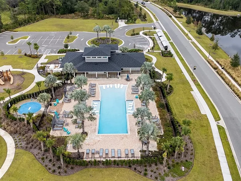 Aerial view of community amenities featuring resort-style pool, clubhouse, fitness center, and walking paths within The Sanctuary community.