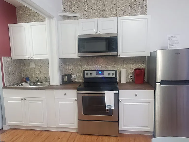 The kitchen includes a refrigerator, oven, microwave, coffee maker, and essential amenities.