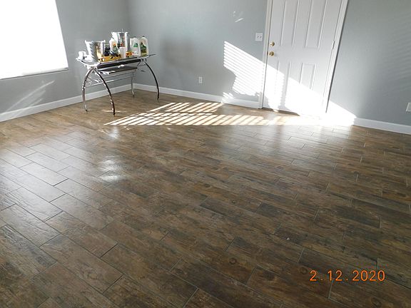 Open living room completely renovated with new two tone paint, porcelain plank tile flooring and new baseboard